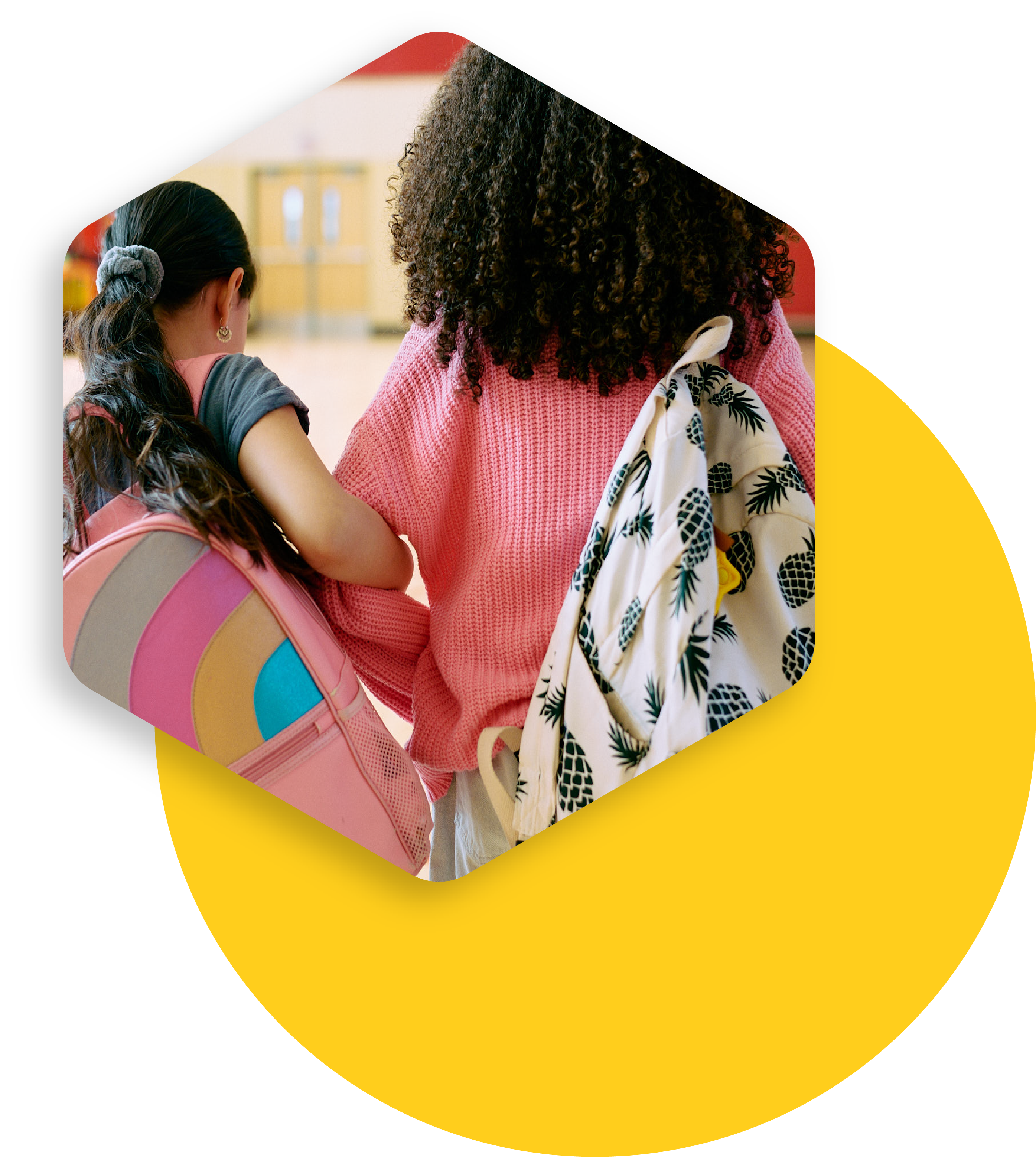 Two girls in the school hallway with bookbags