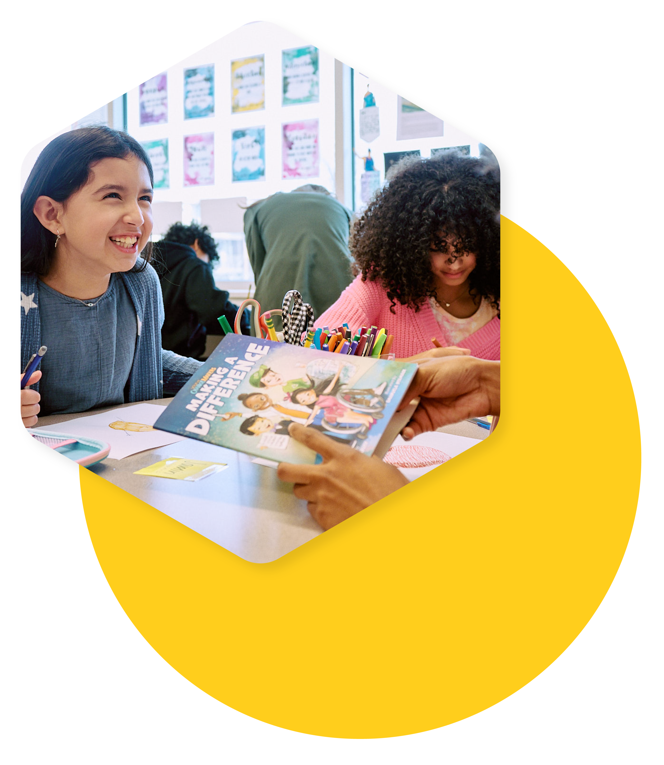 students reading a book at a table in a classroom